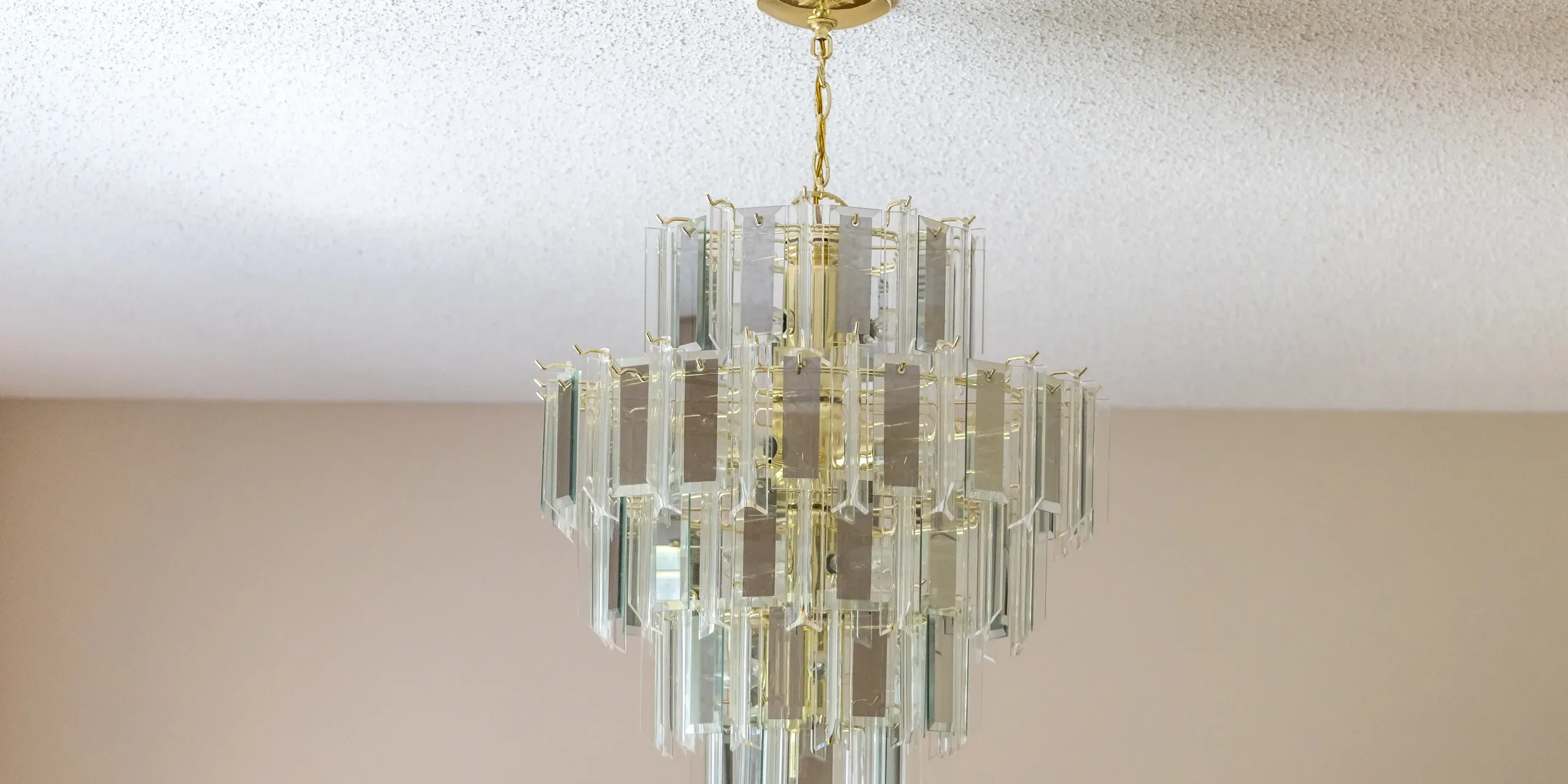 An old-fashioned retro hanging glass chandelier in a dining room popcorn ceiling