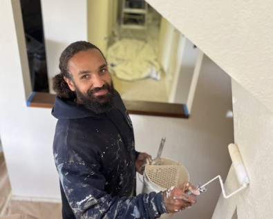 Rogall painter rolling fresh paint on an interior stairwell wall